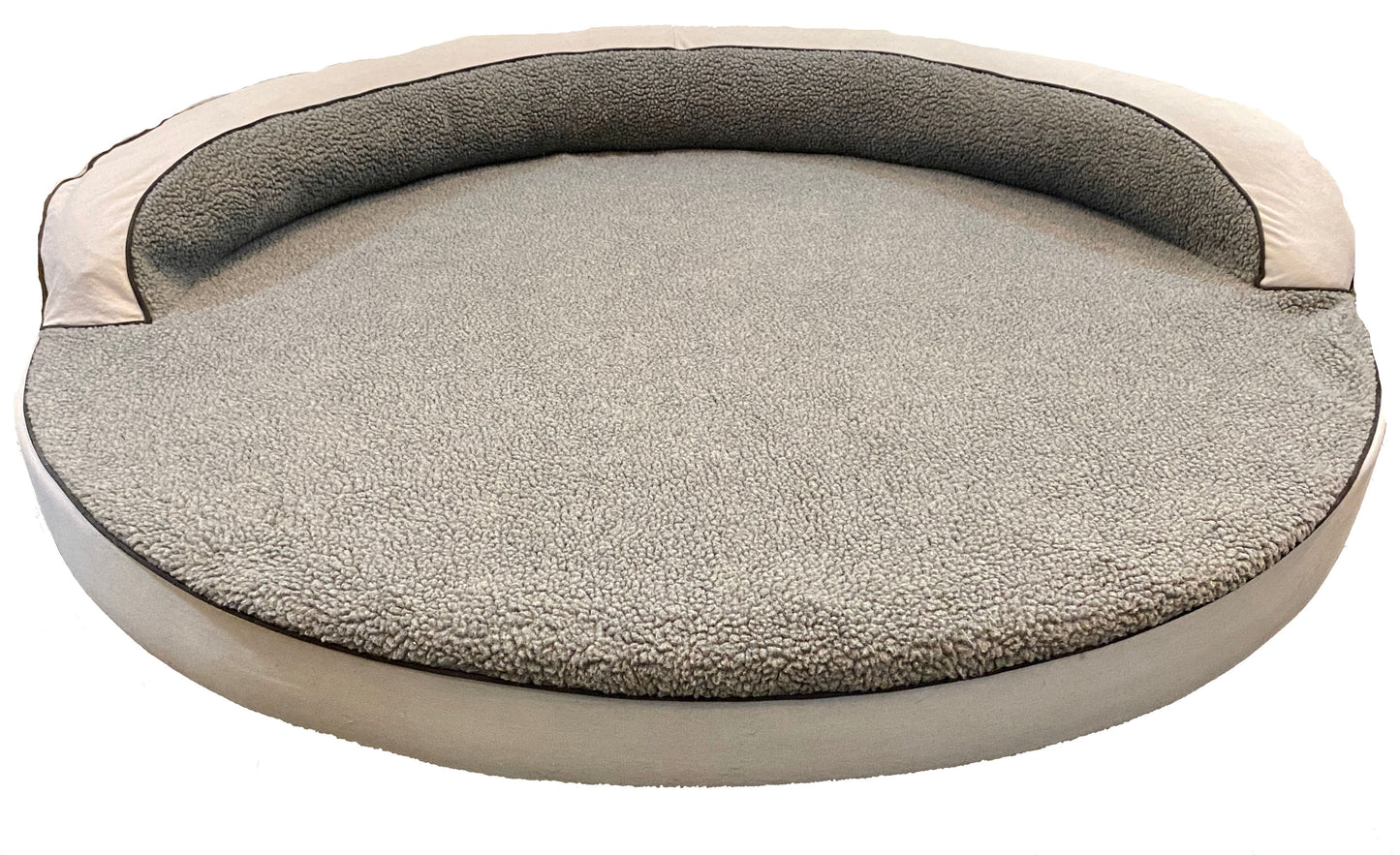 Large round dog bed with plush sherpa top and raised bolster edges in gray 
