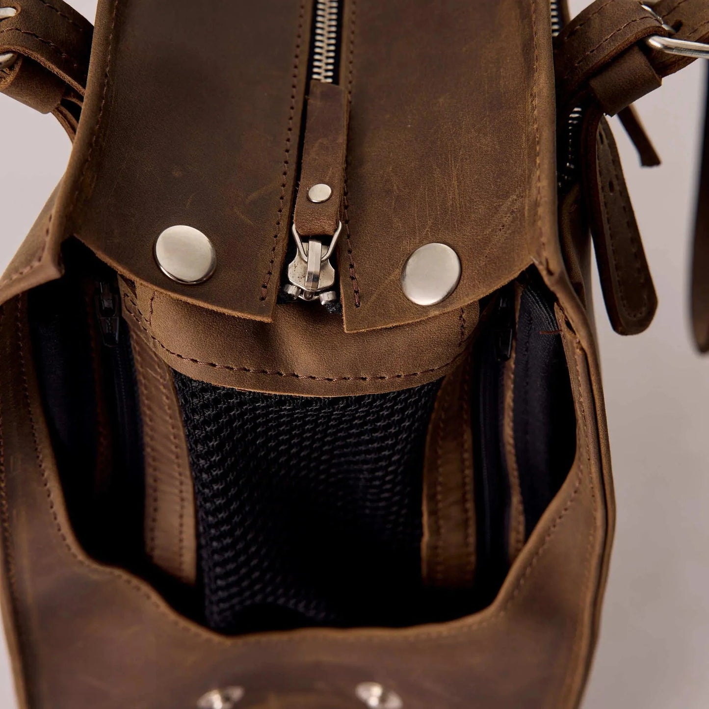 Close-up of a brown leather bag with a black interior pocket.